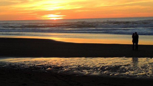 Lovers on the beach at sunset
